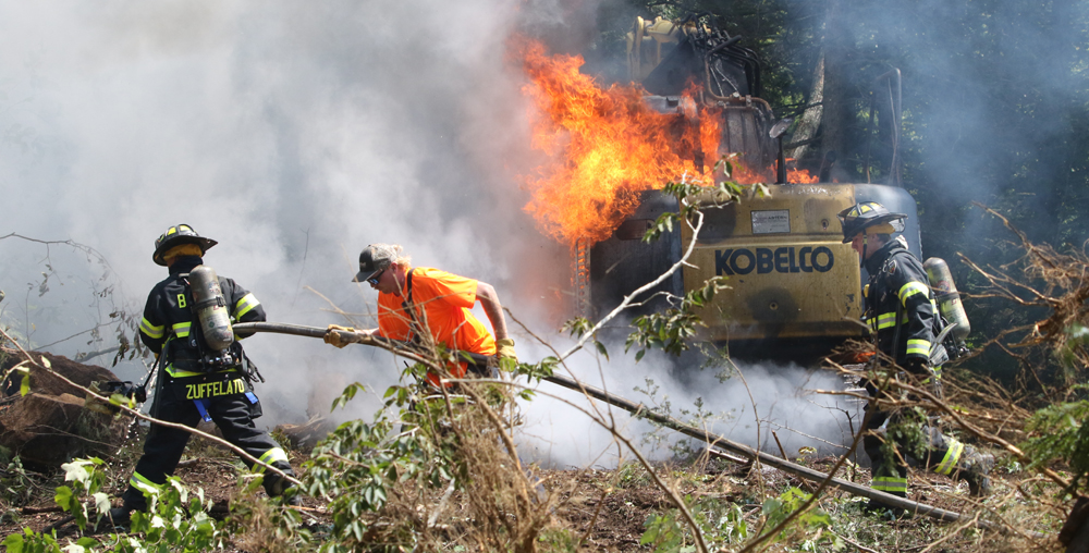 Excavator clearing land destroyed by fire