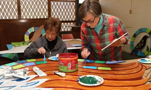 Volunteers apply their art touch to mural