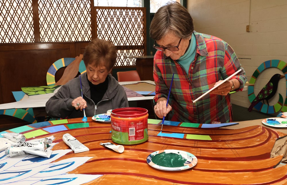 Volunteers apply their art touch to mural