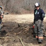 Firefighters douse burning brush piles