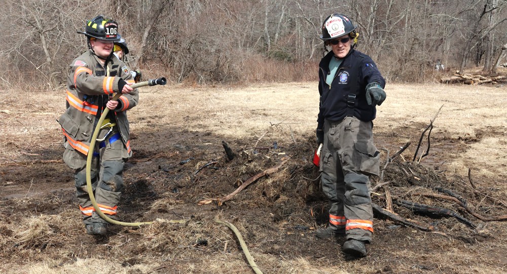 Firefighters douse burning brush piles