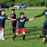 Young soccer players learning from a pro