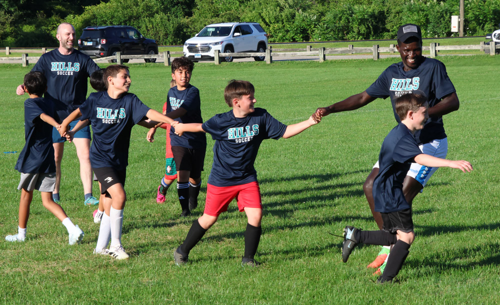 Young soccer players learning from a pro