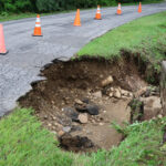 Wall of water damages road in Warren